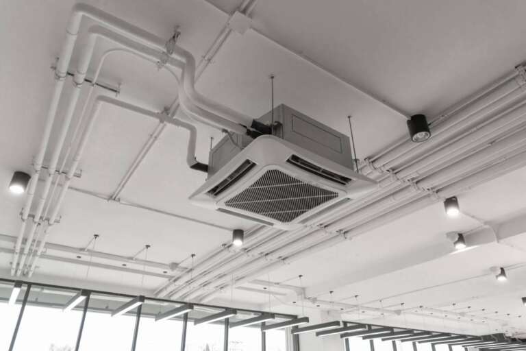 Modern white ceiling mounted cassette type air conditioner in office building system work. Ventilation compressor.