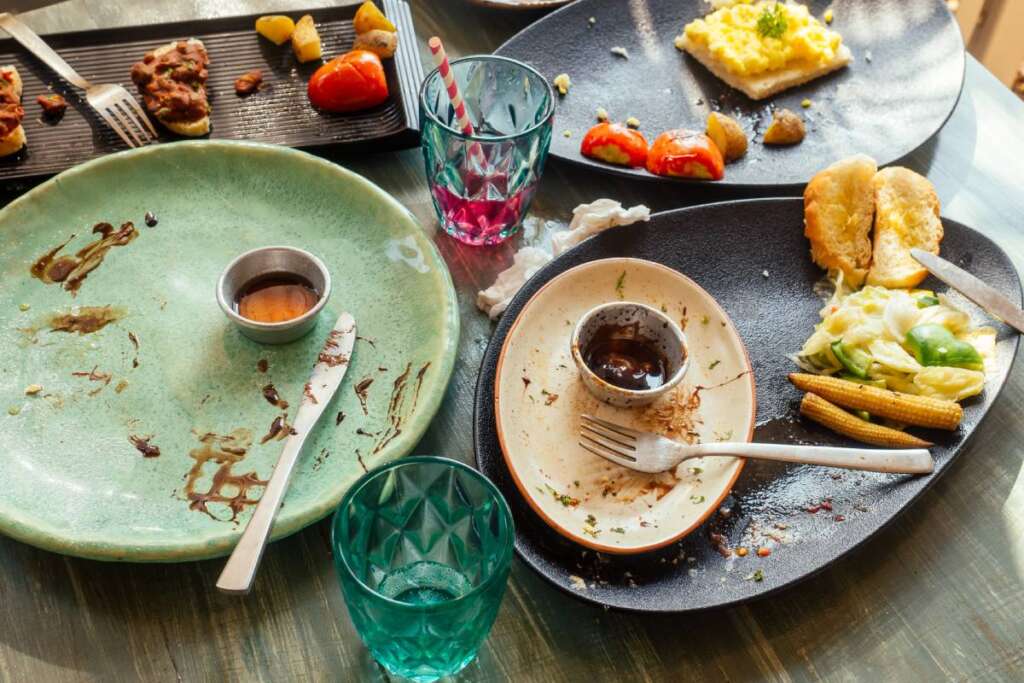 dirty dishes plates and glass on the table in cafe.