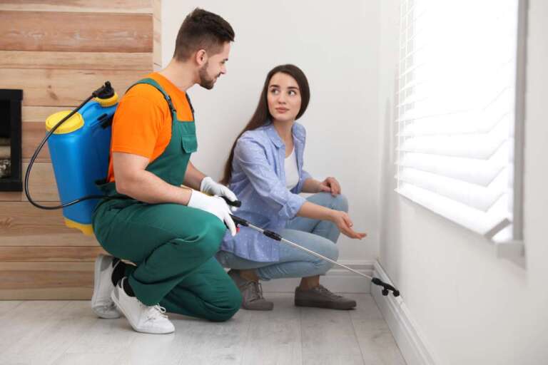 Woman showing insect traces to pest control worker at home